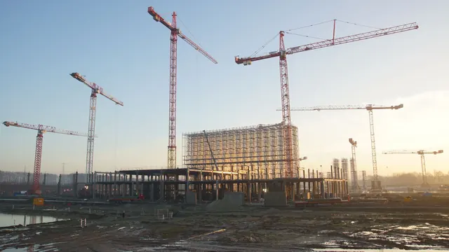 夕陽下的建築工地與吊車，說明建商經營風險